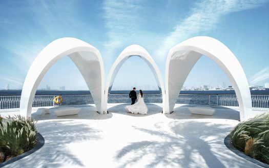 Couple de mariés devant une structure moderne avec vue sur Dubaï